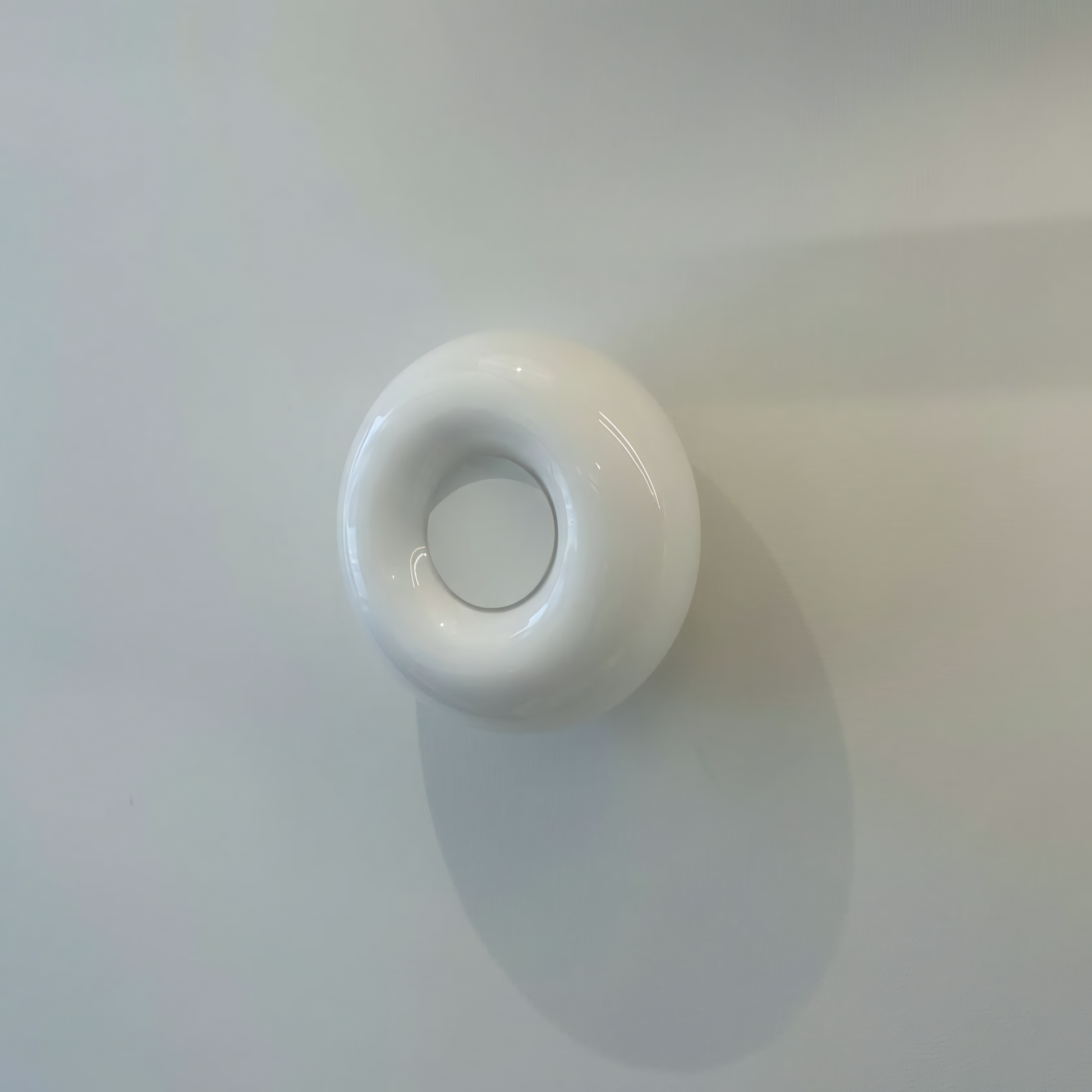 White round light switch on a white wall