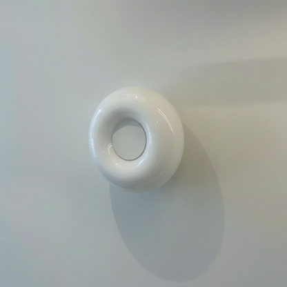 White round light switch on a white wall